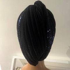 A black turban displayed on a mannequin head.
