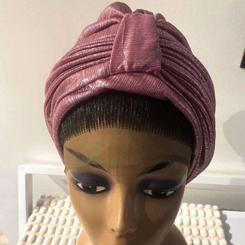 A mannequin head wearing a pink turban with a visible textured fabric.