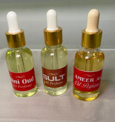 Three glass bottles with white dropper caps, labeled Mini Oud, Oud, and Amer Al Oud Oil Perfume, filled with a yellow liquid.