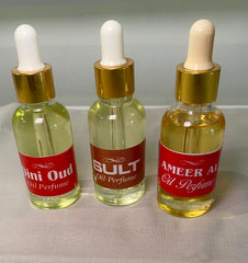 Three glass bottles with white dropper caps, labeled Mini Oud, Oud, and Amer Al Oud Oil Perfume, filled with a yellow liquid.