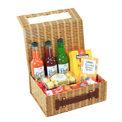 A wicker gift basket hamper containing various food items including bottles of sauce, a box of biscuits, and other snacks.
