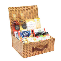 An extra large wicker hamper gift box with an assortment of food items including meats, cheeses, and crackers.