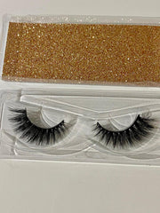 Pair of false eyelashes in a clear packaging with gold glittery strip