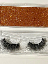 eyelashes in a packaging case with a glittery brown strip.