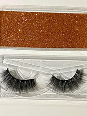 eyelashes in a packaging case with a glittery brown strip.