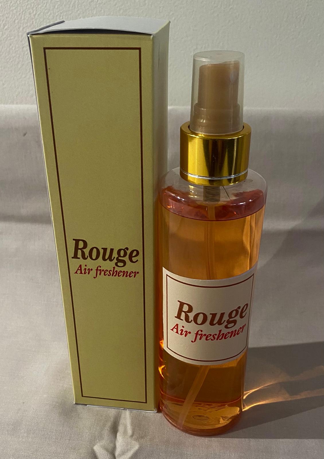 A collection of spray bottles with various home care fragrance labels, displayed on a table.