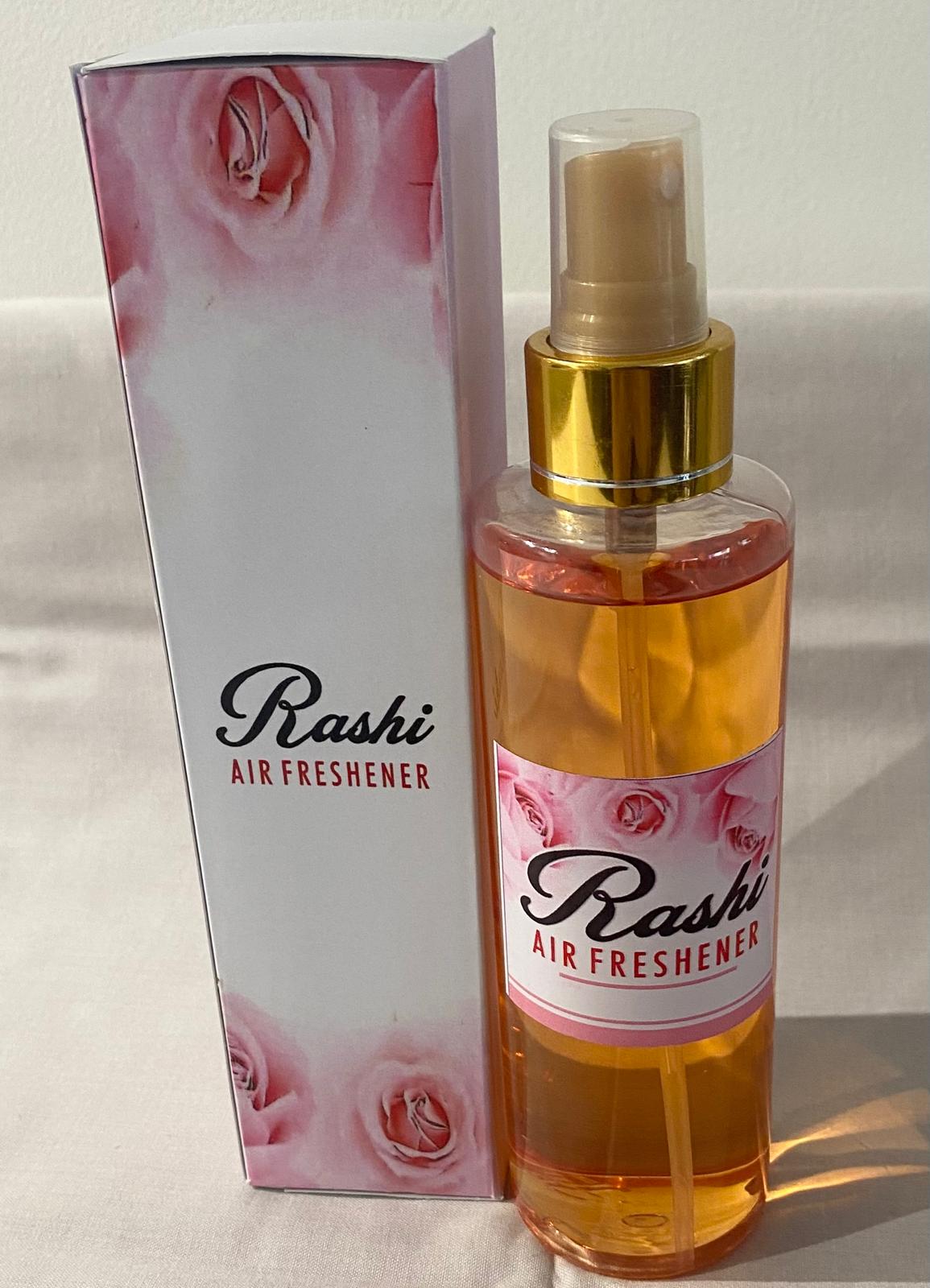 A collection of spray bottles with various home care fragrance labels, displayed on a table. The labels indicate different scent options.