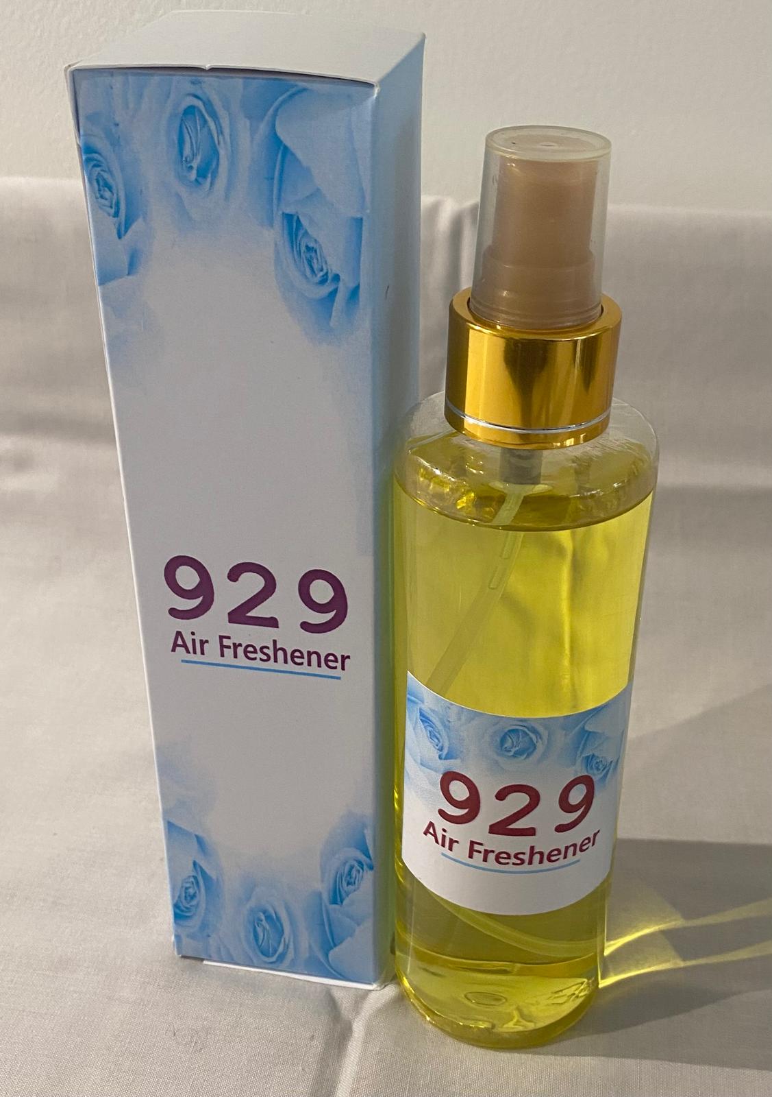 A collection of spray bottles with various home care fragrance labels, displayed on a table.