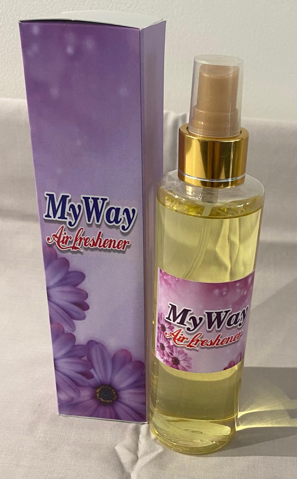 A collection of spray bottles with various home care fragrance labels, displayed on a table.