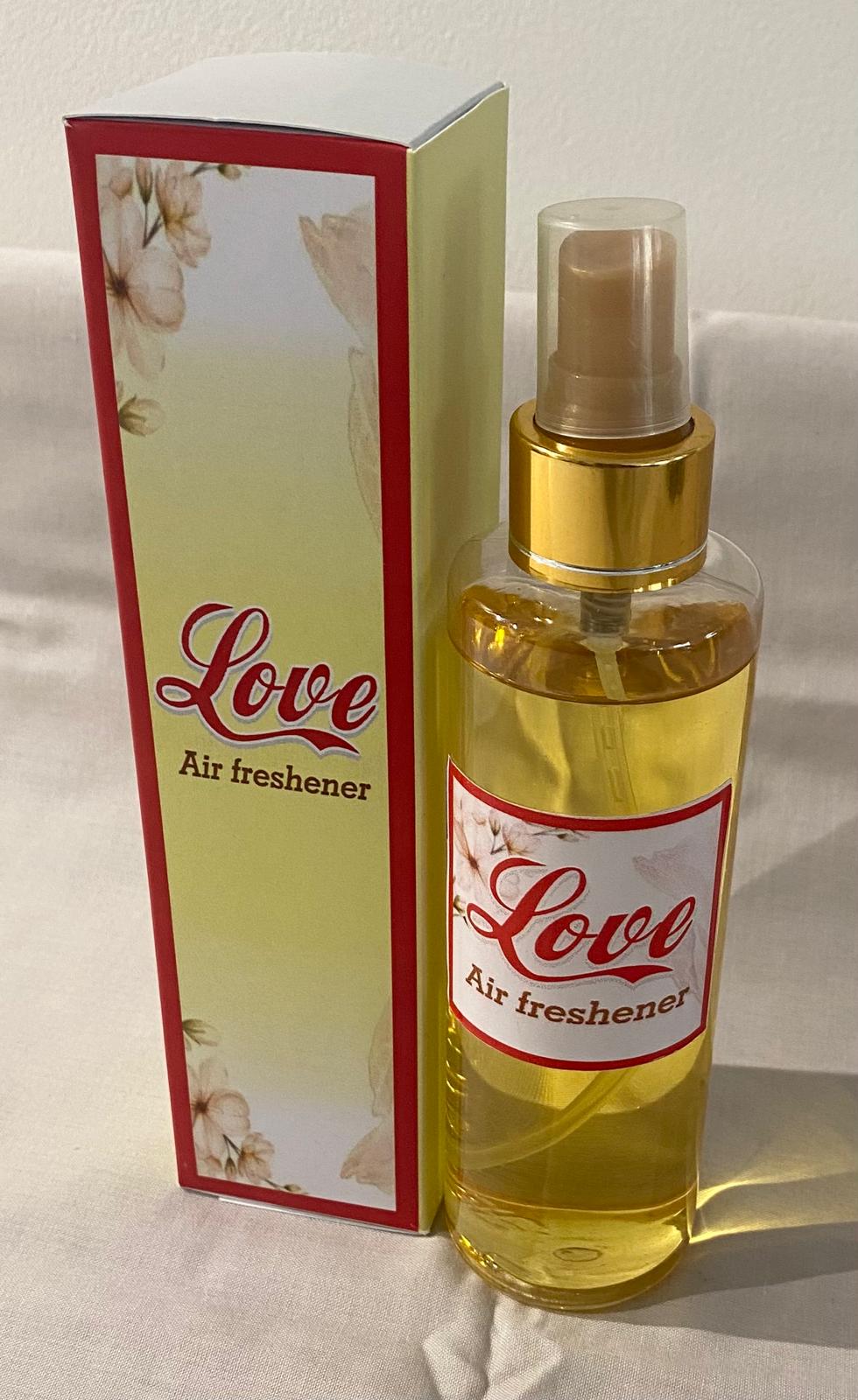 A collection of spray bottles with various home care fragrance labels, displayed on a table.