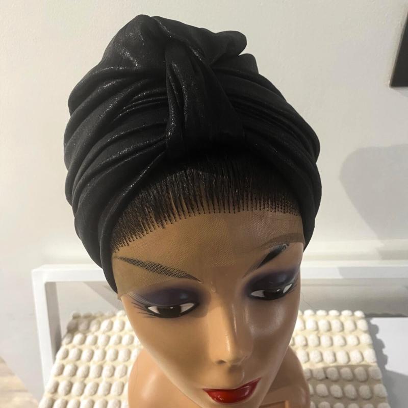 A black turban displayed on a mannequin head.