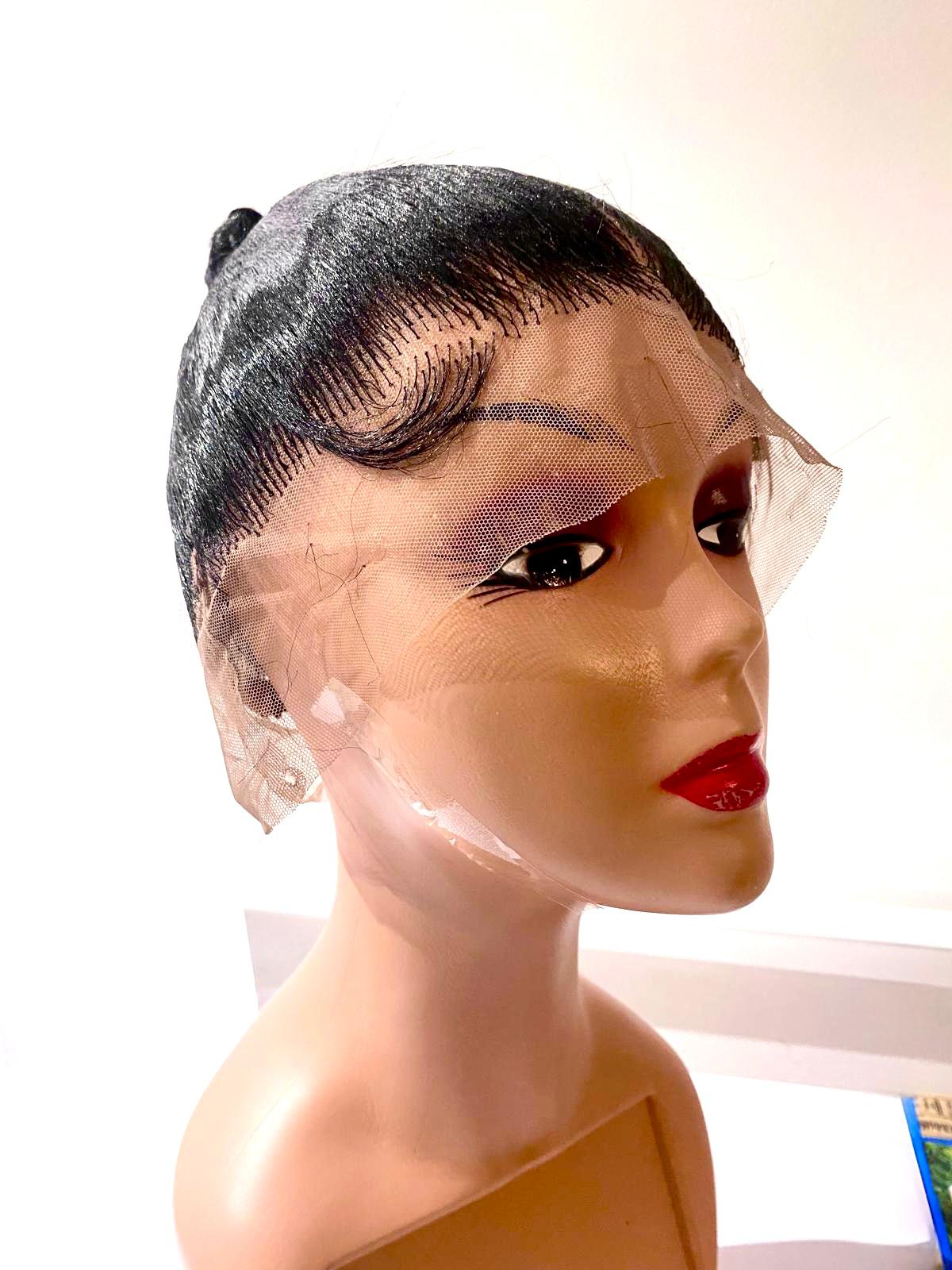 Mannequin head with a black lace wig on a white background