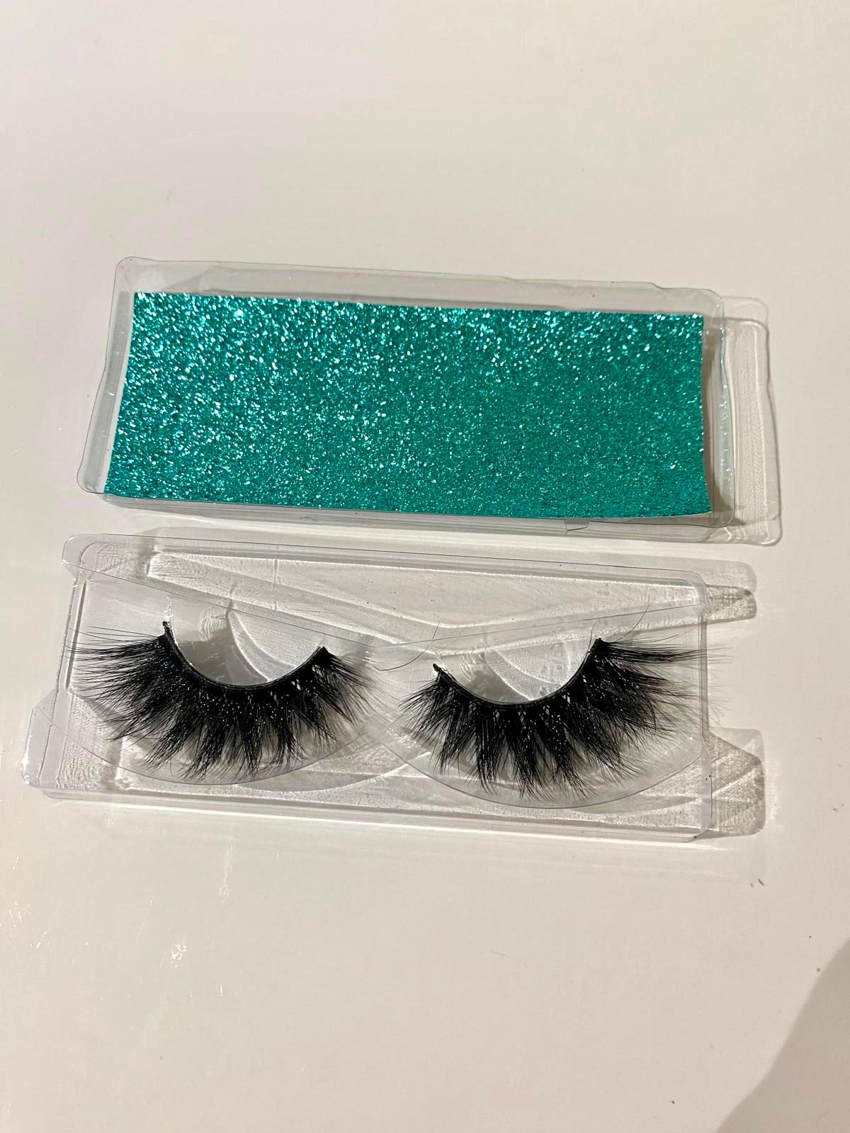 Pair of false eyelashes in a clear case with a turquoise strip on a white background