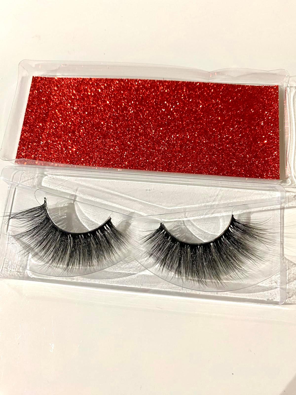 Pair of false eyelashes in a clear packaging with a red glittery background