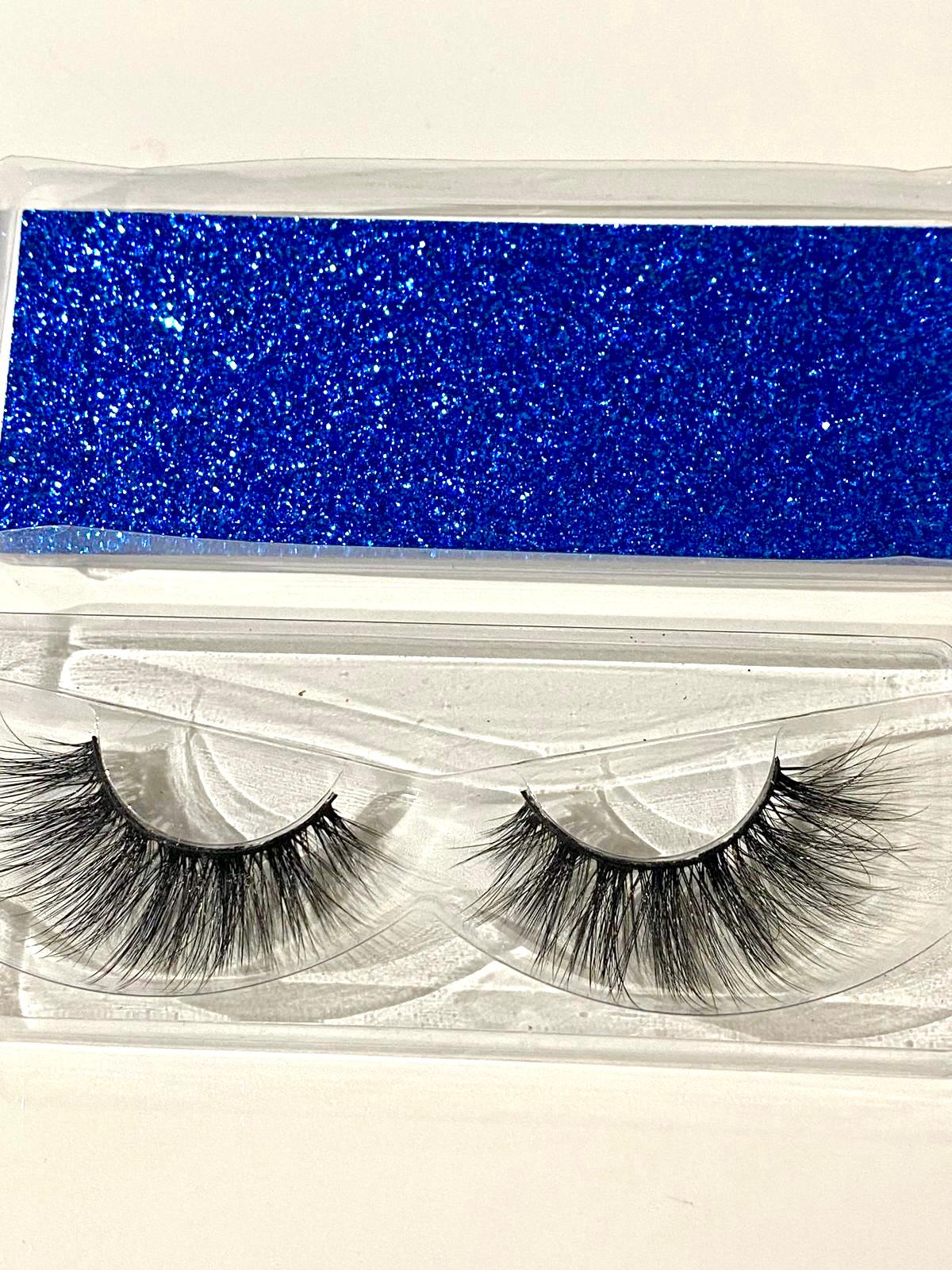 Pair of false eyelashes in a blue glittery case on a white background